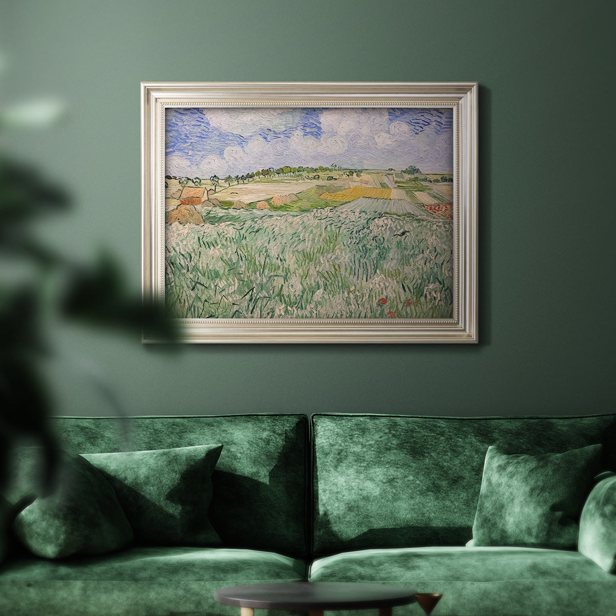 Impressionist countryside landscape near Auvers by Vincent van Gogh in an ornate champagne frame displayed in a dark-toned interior setting.