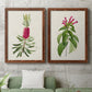 Set of two maple barnwood framed canvas prints depicting a coordinated art pair of pink flowering plant specimens rendered as vintage botanical plate illustrations above a sofa in a modern living room.
