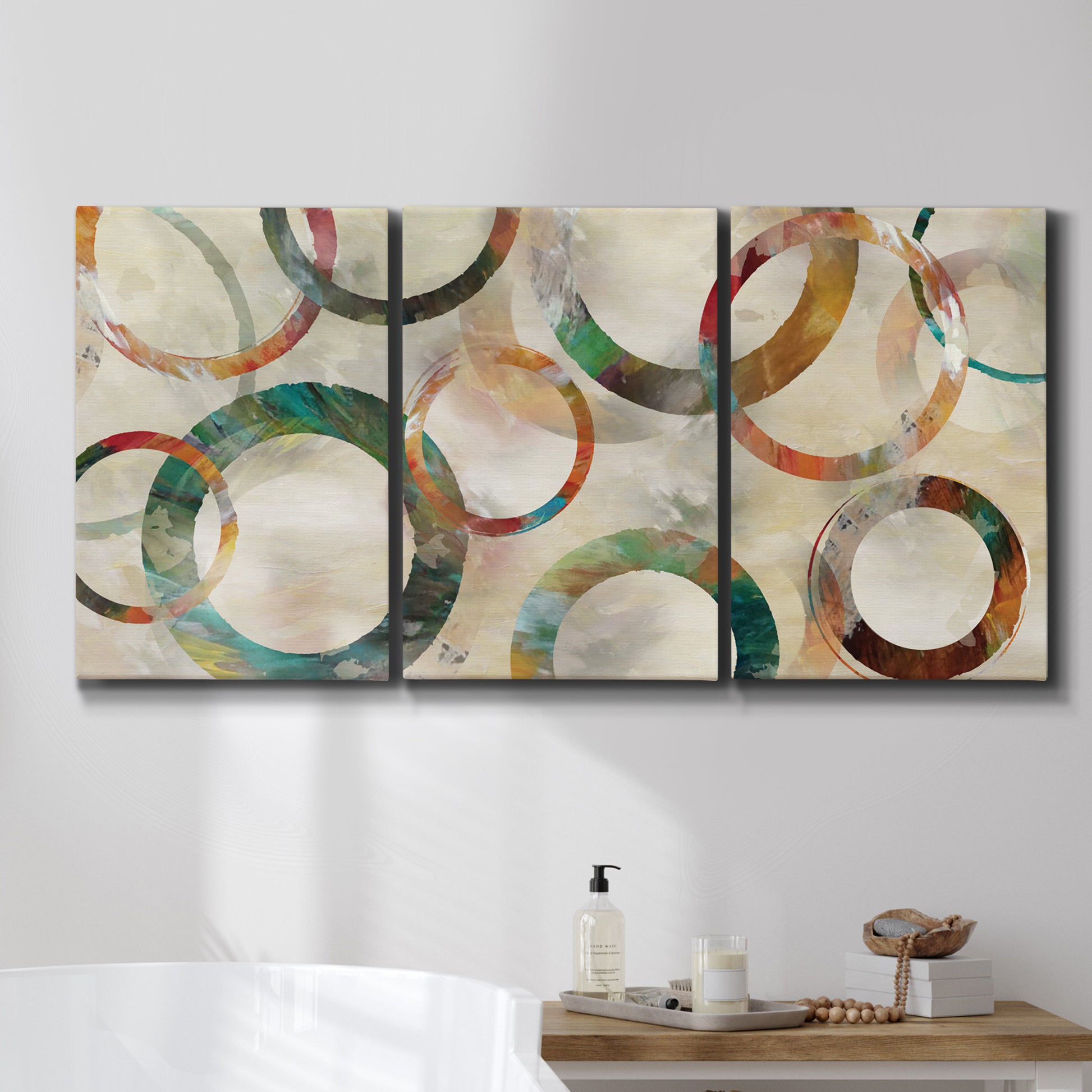 Three-panel canvas wall art featuring geometric circular abstract design, displayed in a bathroom above a bathtub.