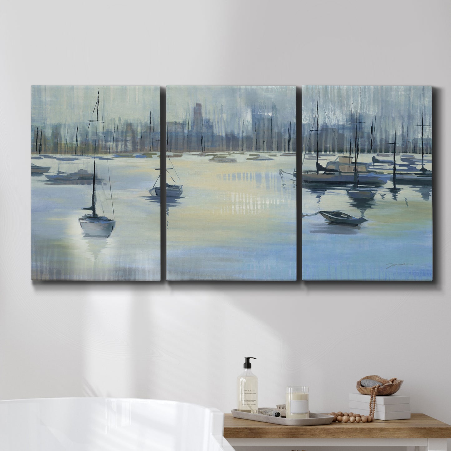 Three-panel canvas wall art featuring anchored boats near shoreline, displayed in a bathroom above a bathtub.