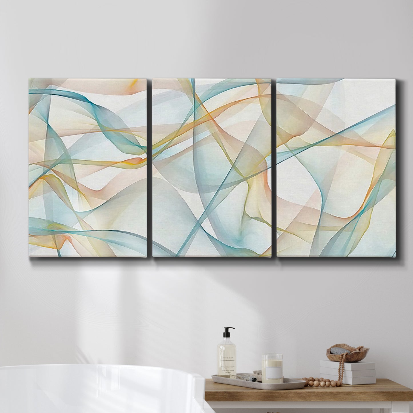 Three-panel canvas wall art featuring flowing abstract curves and wave patterns, displayed in a bathroom above a bathtub.