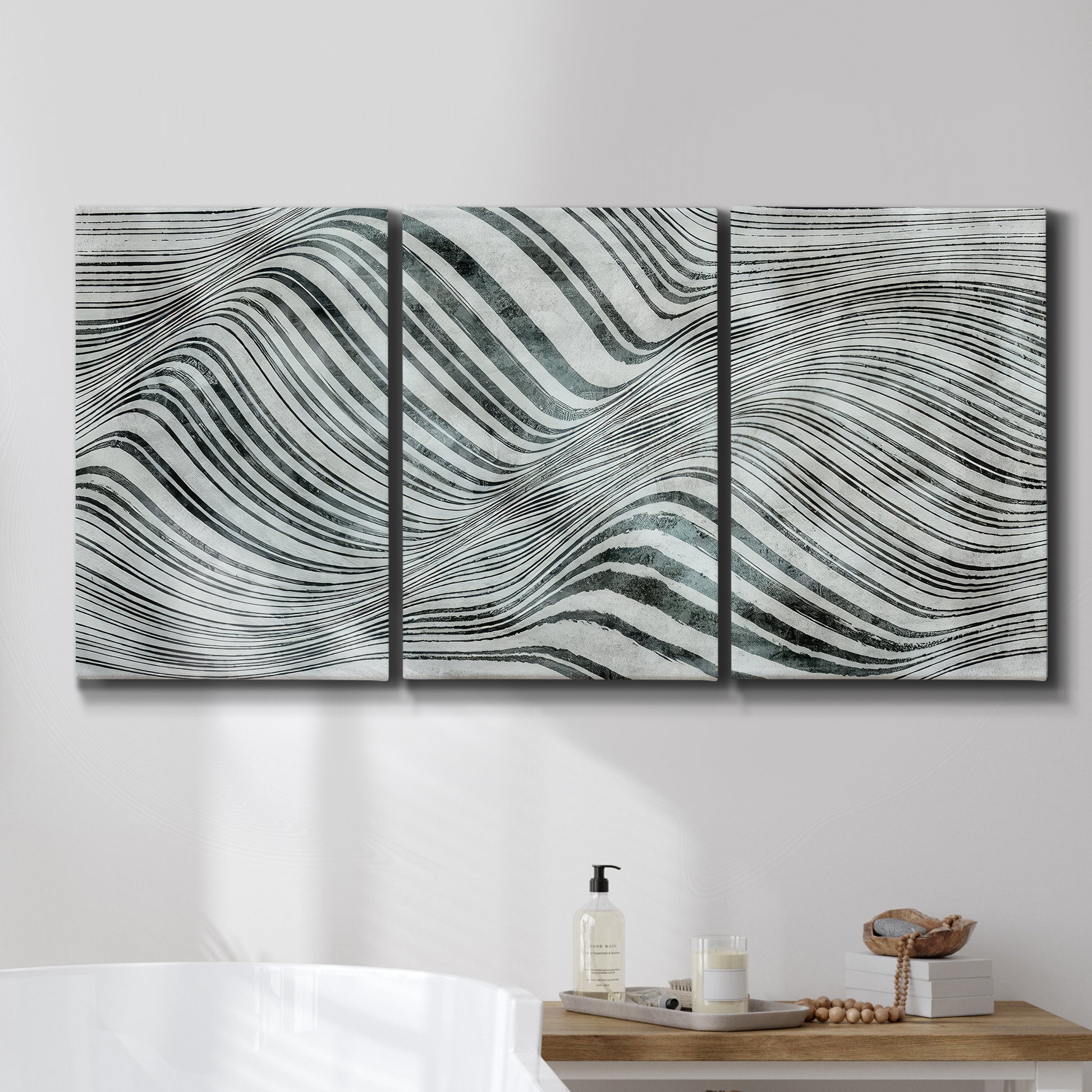 Three-panel canvas wall art featuring coastal shoreline with gentle surf, displayed in a bathroom above a bathtub.
