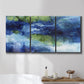 Three-panel canvas wall art featuring flowing blue abstract watercolor, displayed in a bathroom above a bathtub.