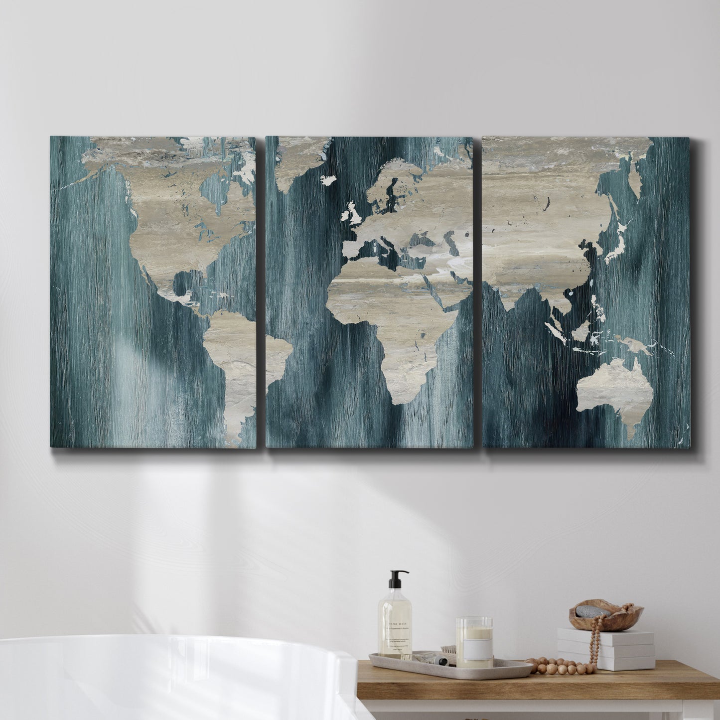 Three-panel canvas wall art featuring golden coastal sunset with cliffs, displayed in a bathroom above a bathtub.
