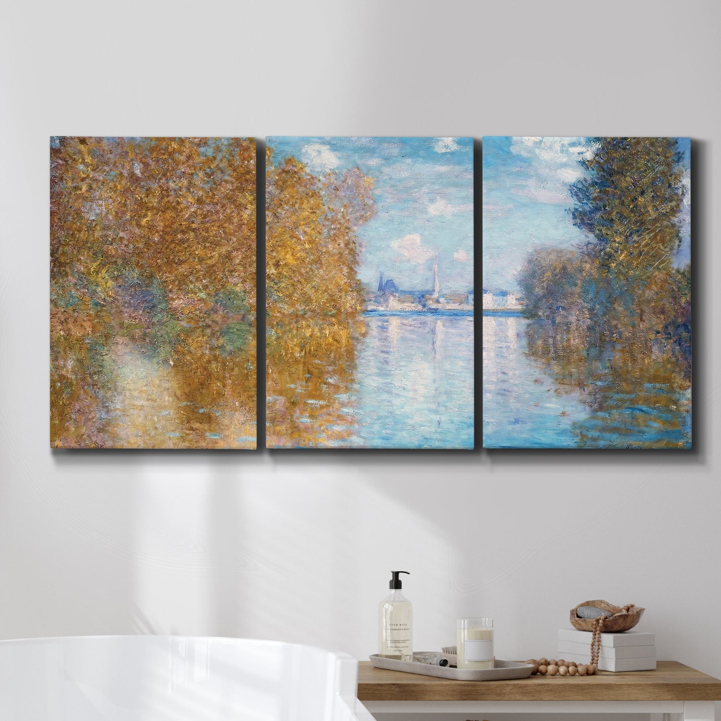 Three-panel canvas wall art featuring autumn landscape with glowing foliage, displayed in a bathroom above a bathtub.