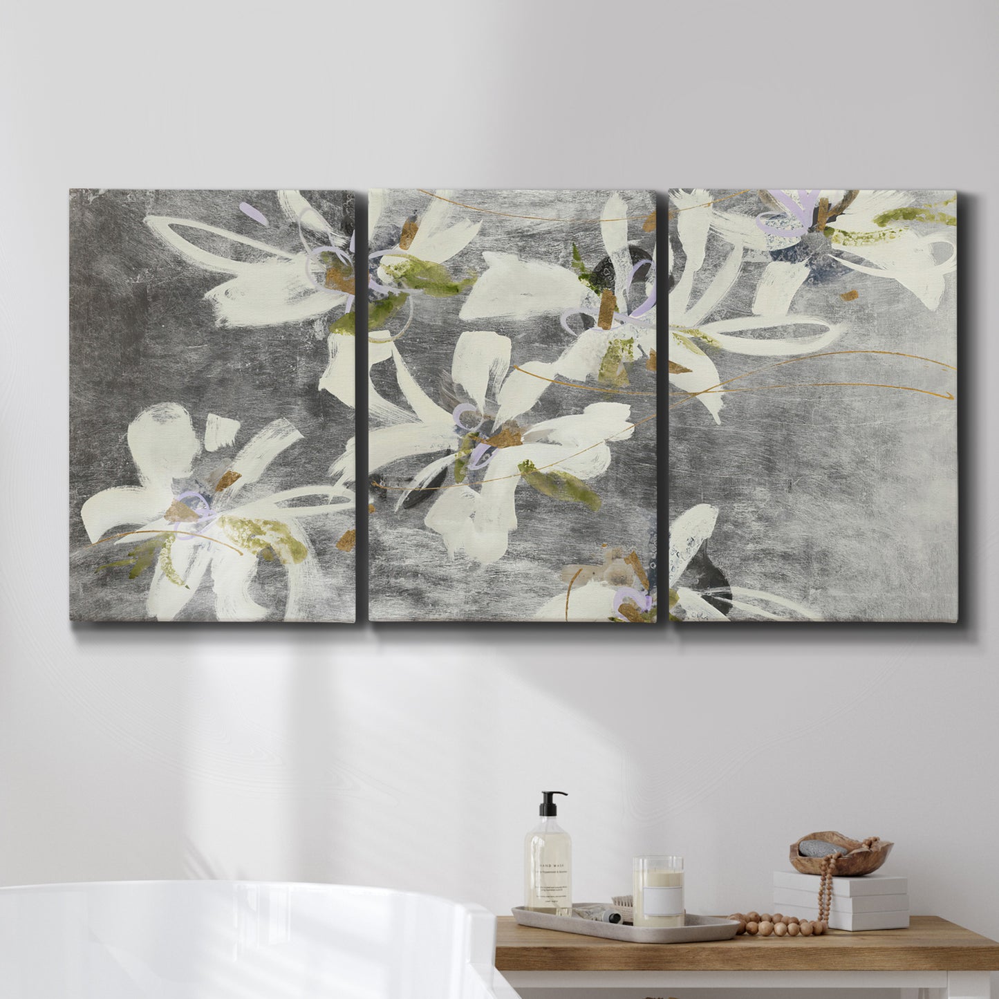 Three-panel canvas wall art featuring delicate floral symbolic arrangement, displayed in a bathroom above a bathtub.