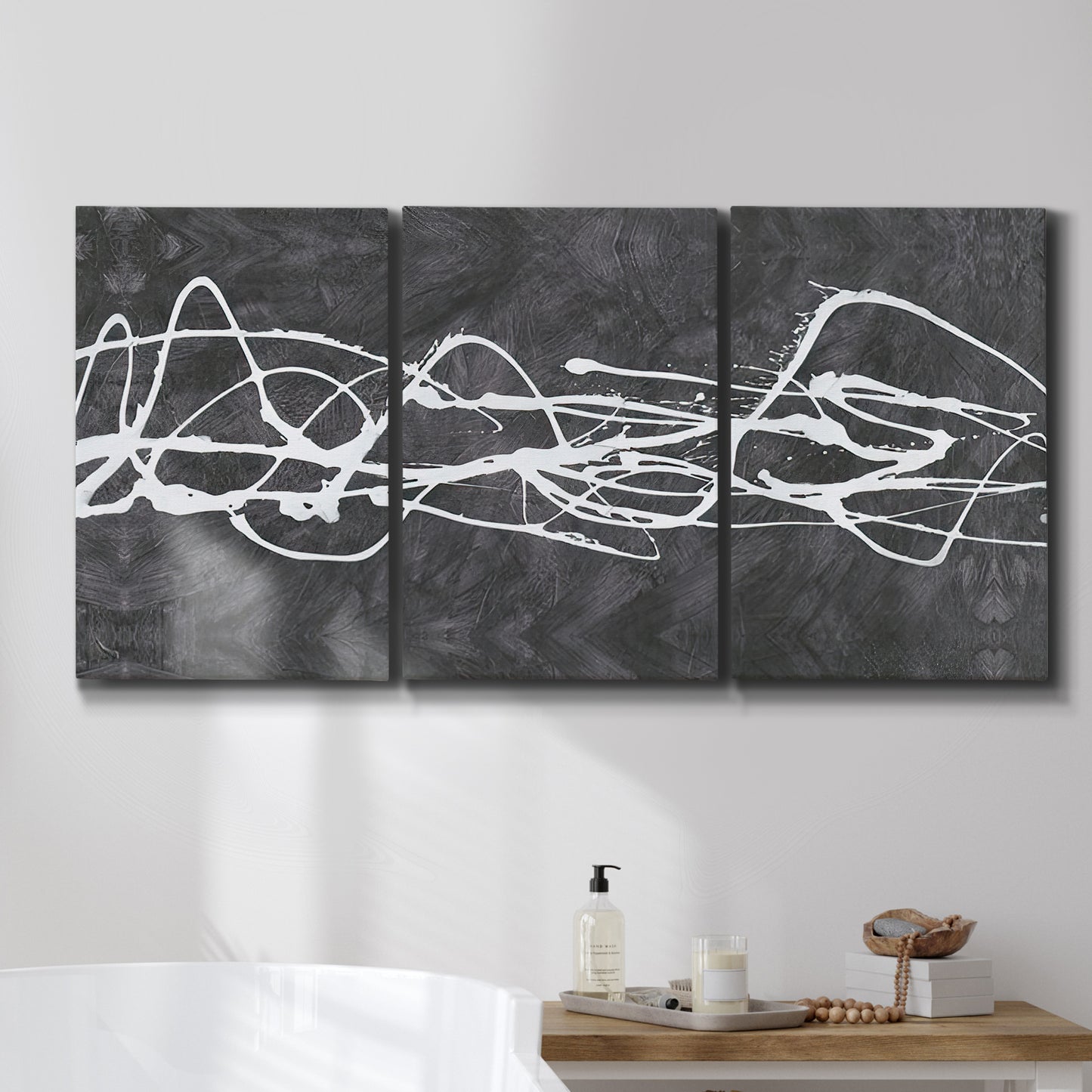 Three-panel canvas wall art featuring minimal abstract frequency lines, displayed in a bathroom above a bathtub.