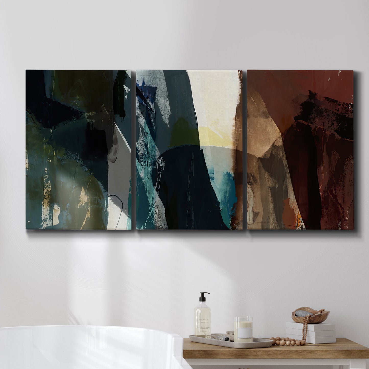 Three-panel canvas wall art featuring layered neutral abstract textures, displayed in a bathroom above a bathtub.