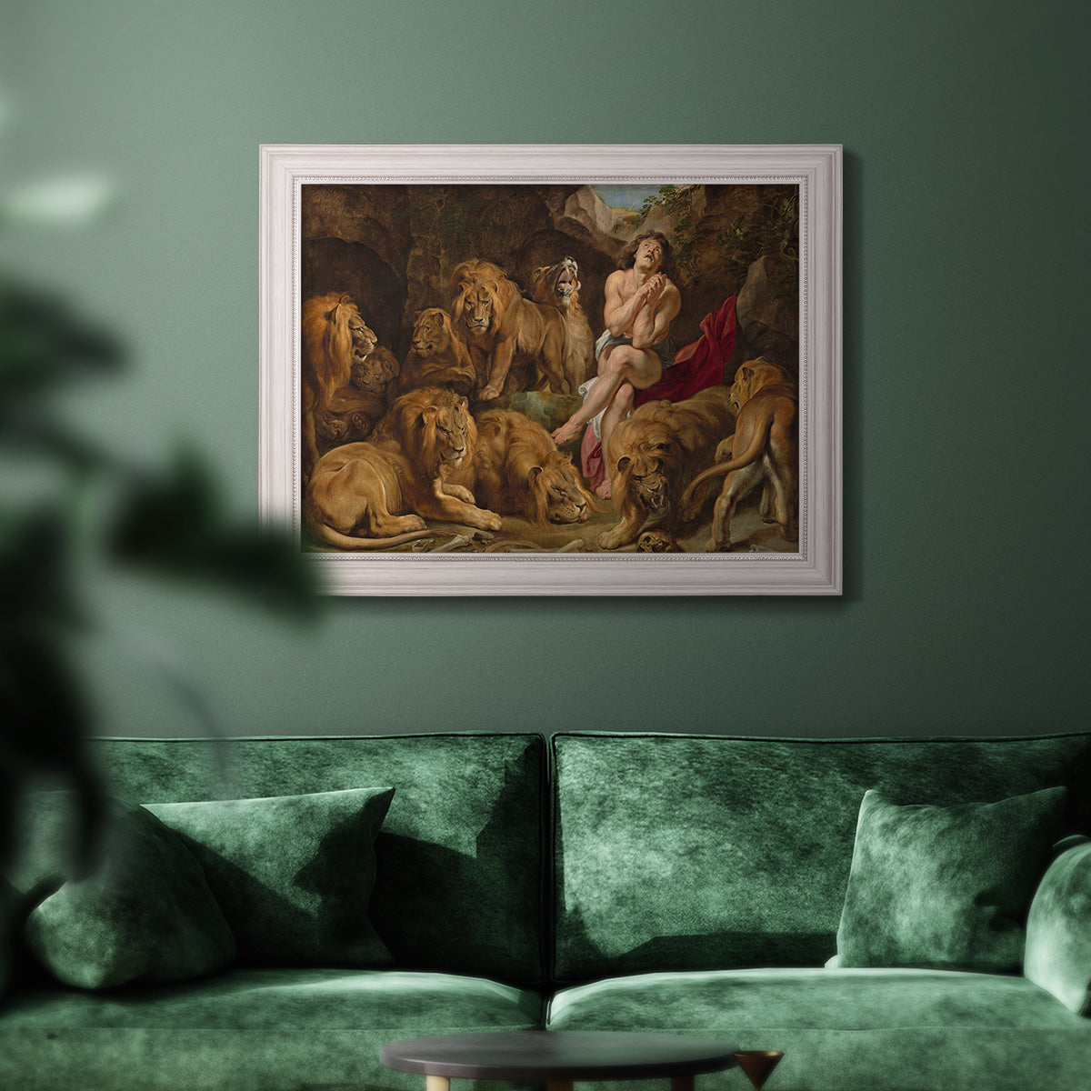 Dramatic biblical painting of Daniel with lions by Peter Paul Rubens in an ornate weathered white frame displayed in a dark-toned interior setting.