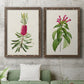 Set of two walnut barnwood framed canvas prints depicting a coordinated art pair of pink flowering plant specimens rendered as vintage botanical plate illustrations above a sofa in a modern living room.