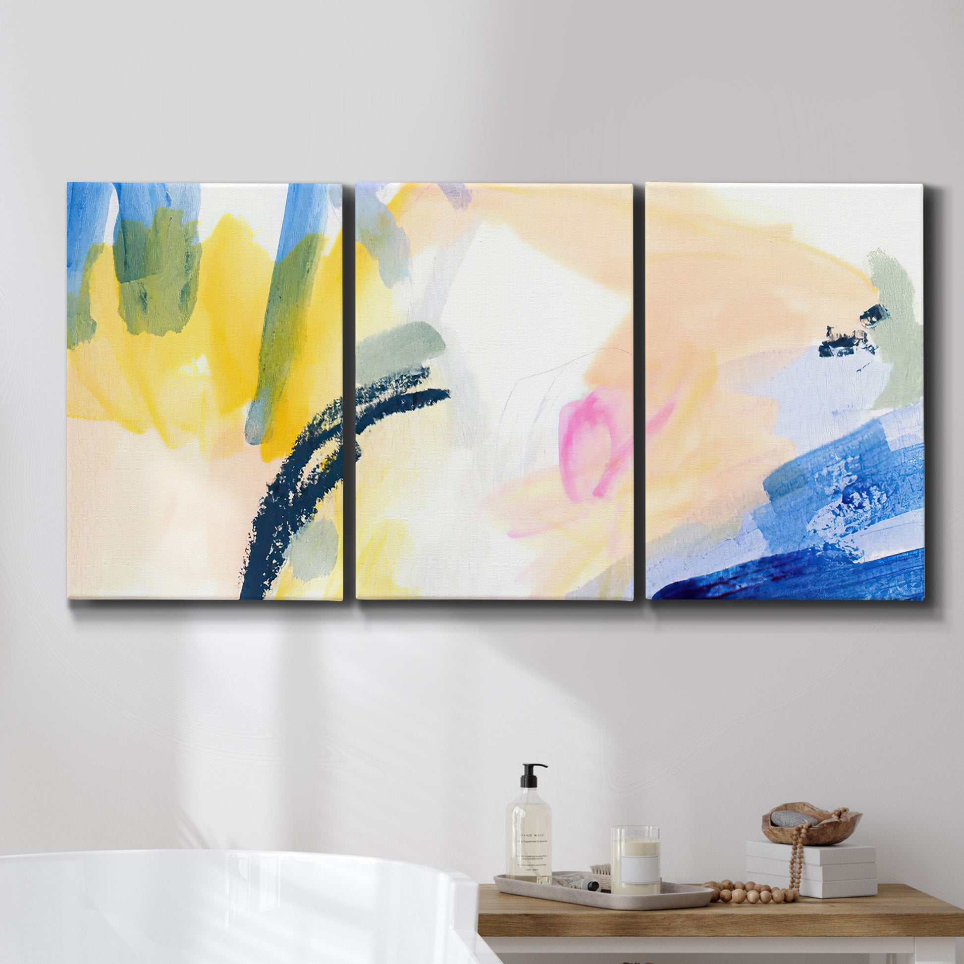 Three-panel canvas wall art featuring bright abstract candy colored strokes, displayed in a bathroom above a bathtub.