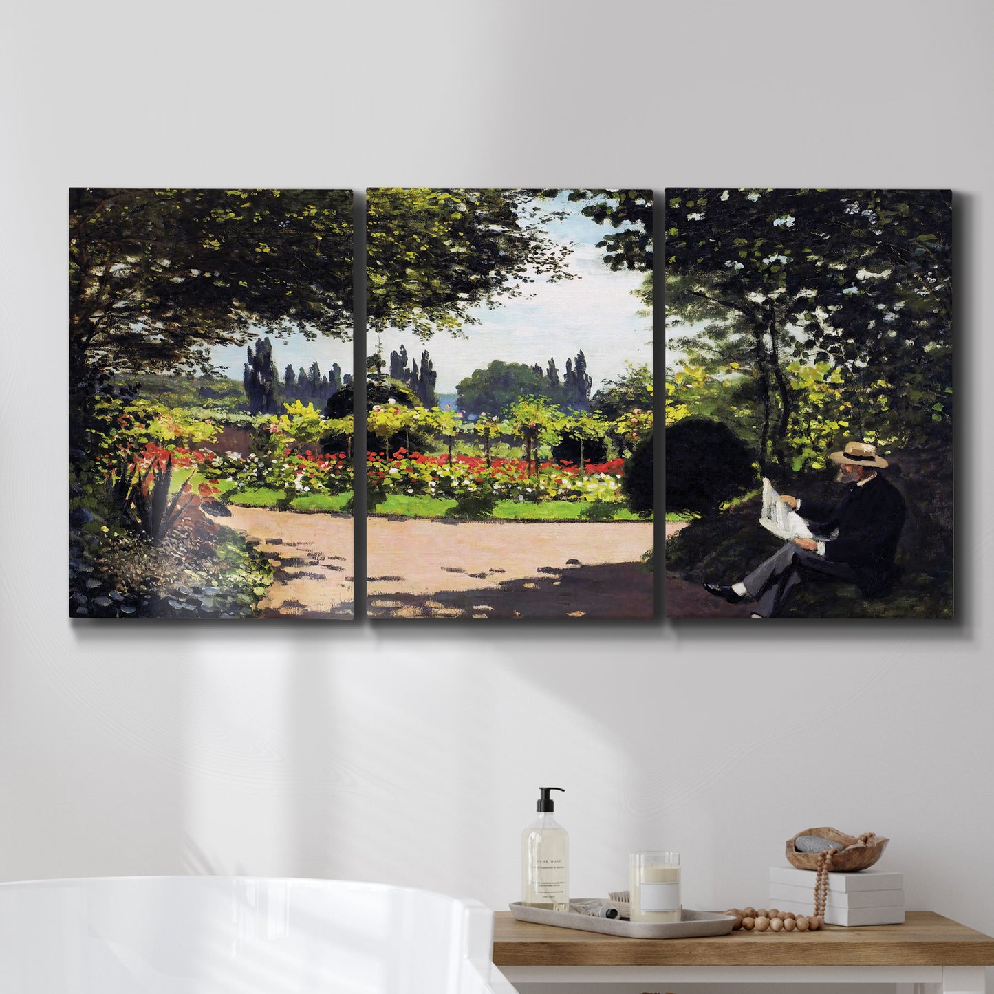 Three-panel canvas wall art featuring coastal garden overlooking sea, displayed in a bathroom above a bathtub.