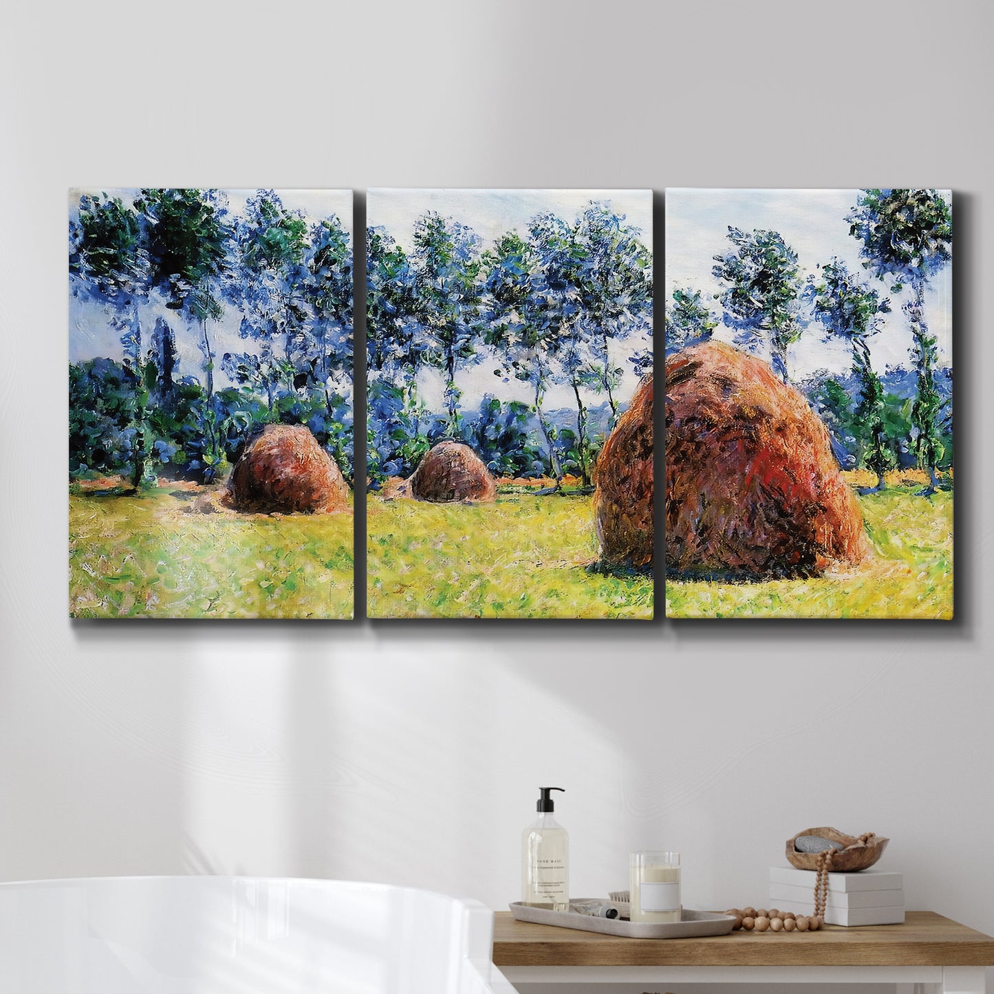 Three-panel canvas wall art featuring harvested grainstacks in field, displayed in a bathroom above a bathtub.