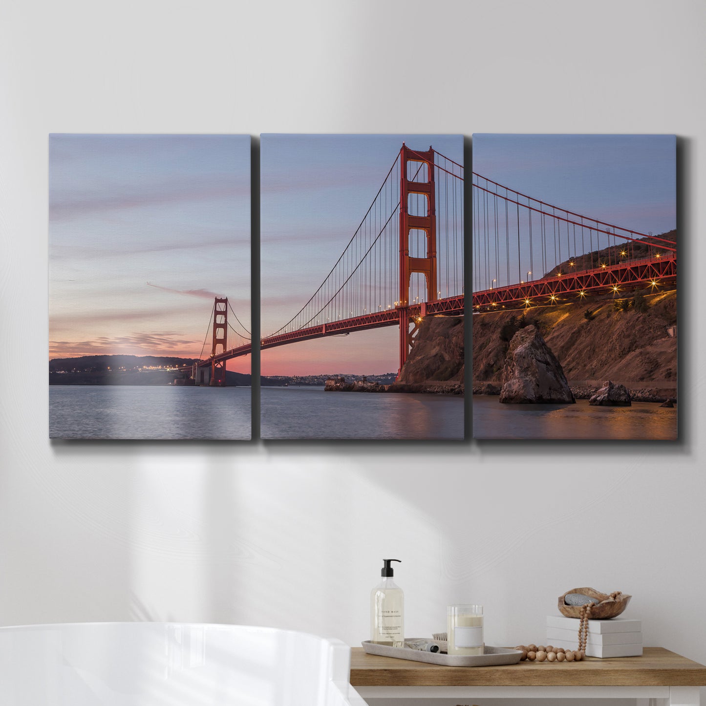 Three-panel canvas wall art featuring golden gate bridge spanning bay, displayed in a bathroom above a bathtub.