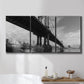 Three-panel canvas wall art featuring manhattan bridge industrial cityscape, displayed in a bathroom above a bathtub.