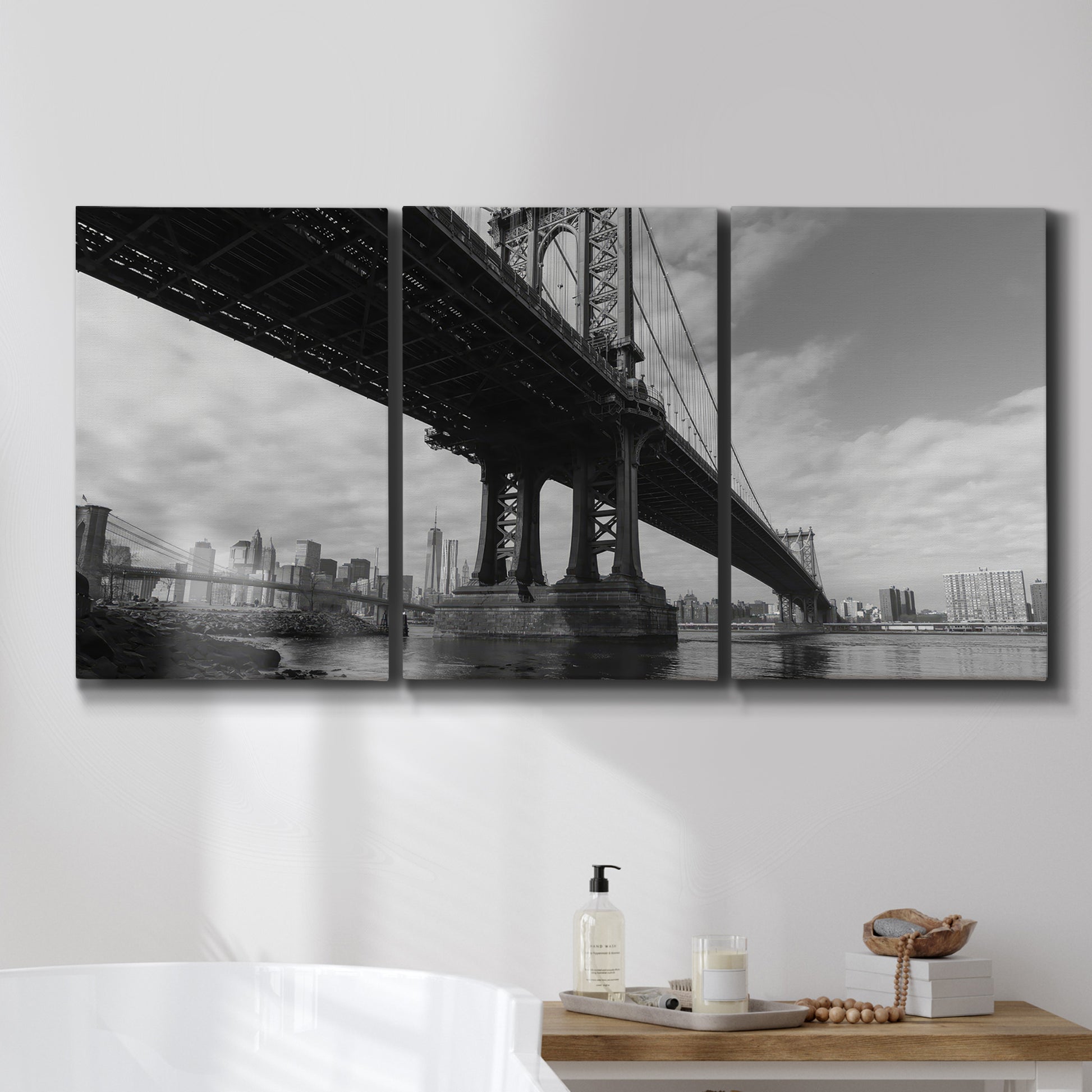 Three-panel canvas wall art featuring manhattan bridge industrial cityscape, displayed in a bathroom above a bathtub.