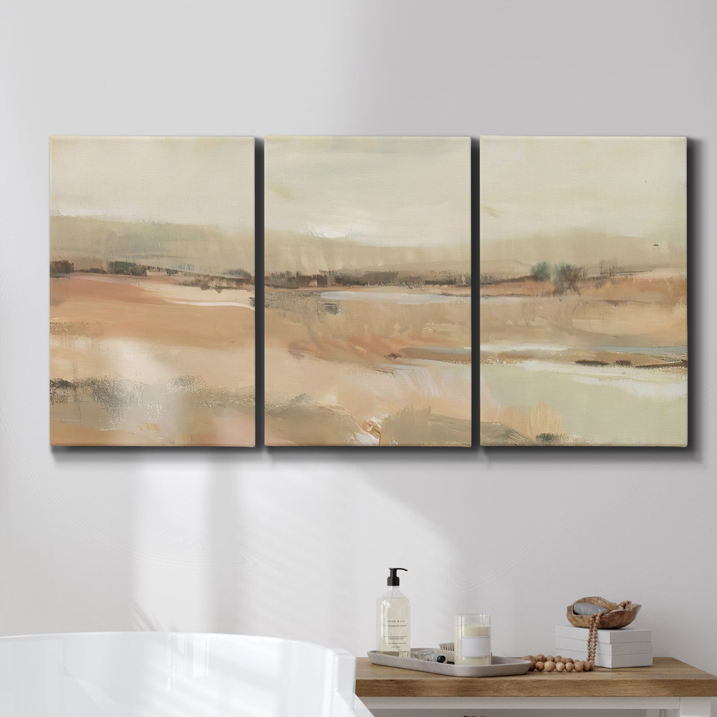 Three-panel canvas wall art featuring earth toned abstract landscape, displayed in a bathroom above a bathtub.