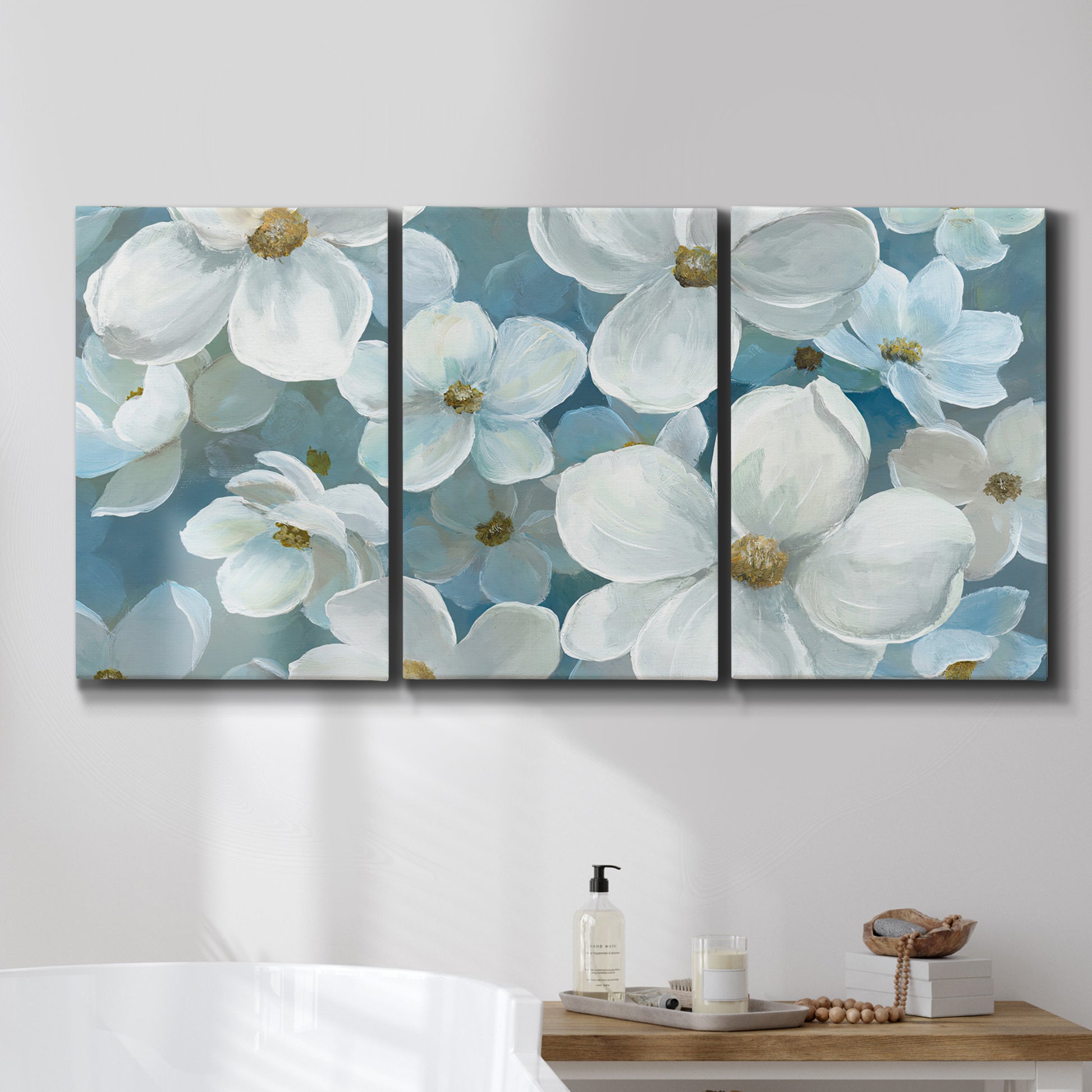 Three-panel canvas wall art featuring soft white floral abstraction, displayed in a bathroom above a bathtub.