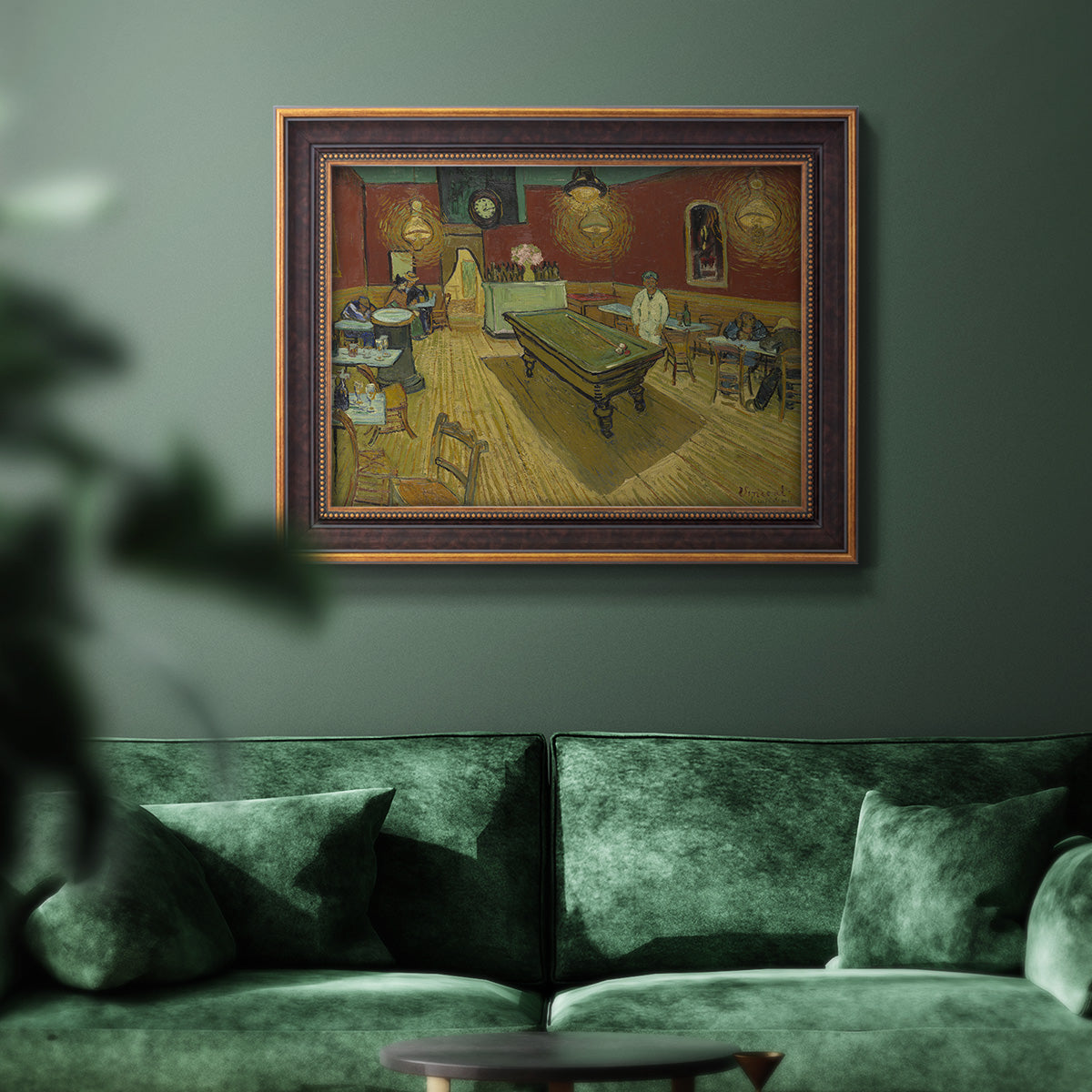 Impressionist interior of a night café by Vincent van Gogh in an ornate bronzed mahogany wood frame displayed in a dark-toned interior setting.