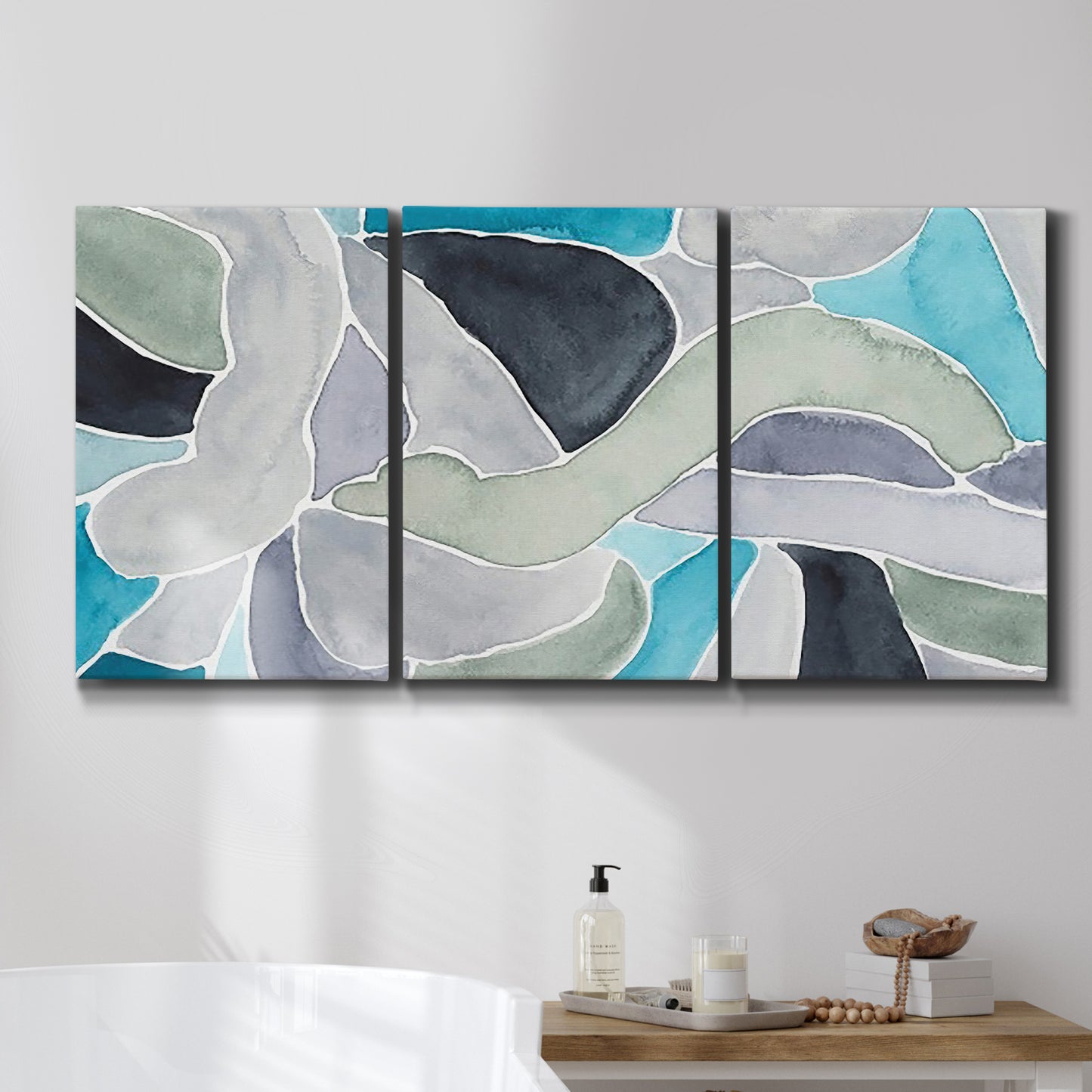 Three-panel canvas wall art featuring subtle abstract billowing color layers, displayed in a bathroom above a bathtub.