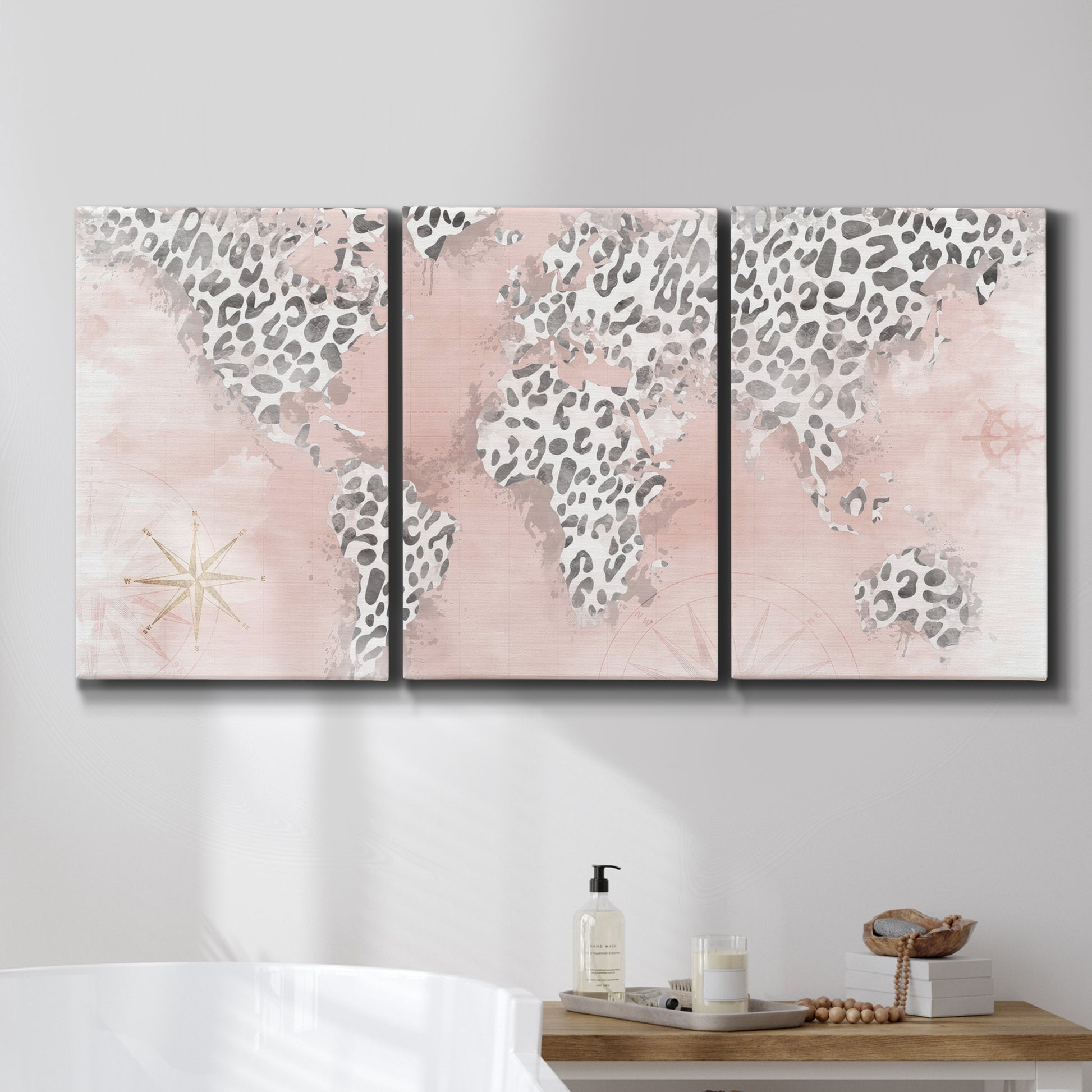 Three-panel canvas wall art featuring stylized pink cheetah world map, displayed in a bathroom above a bathtub.