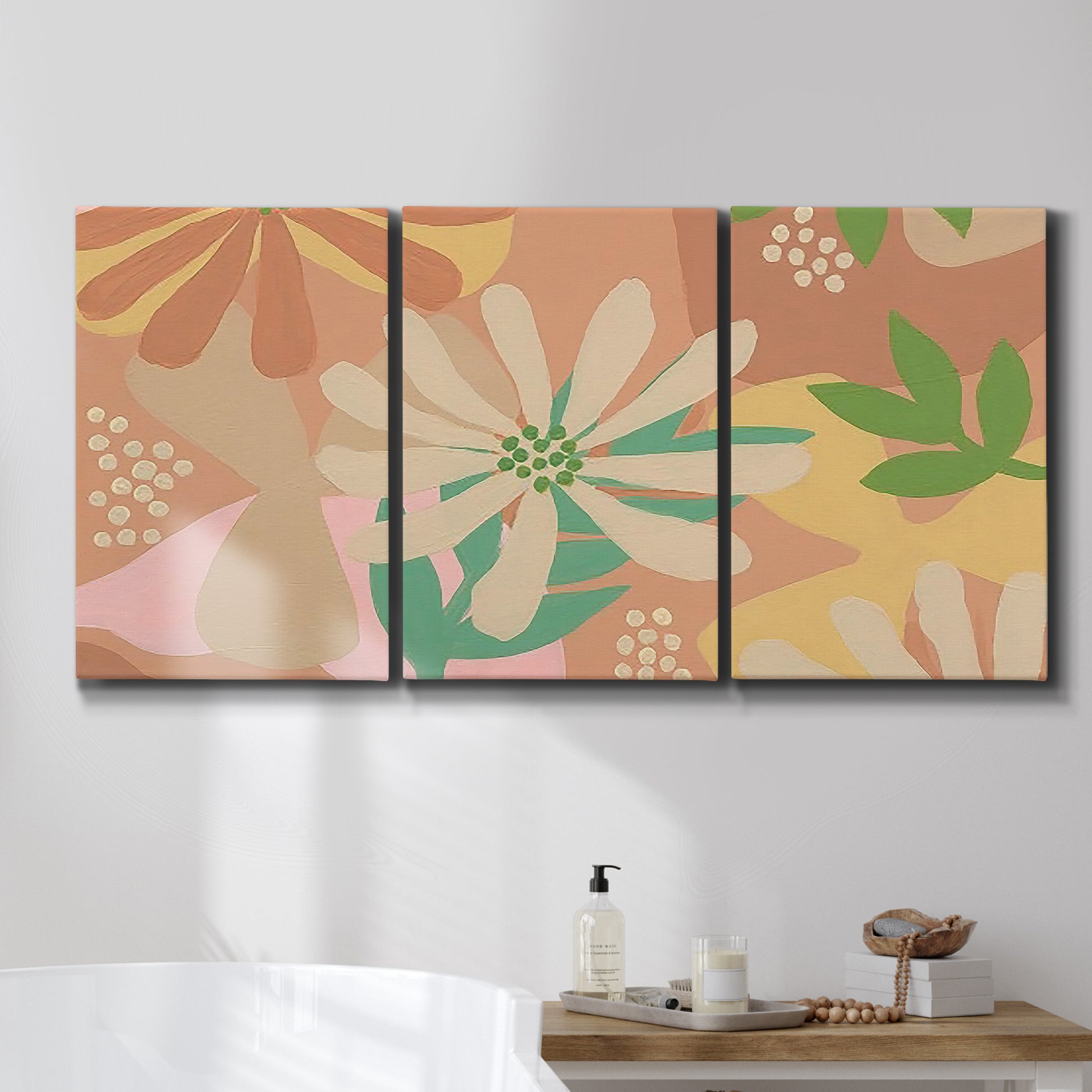 Three-panel canvas wall art featuring neutral toned botanical floral silhouettes, displayed in a bathroom above a bathtub.