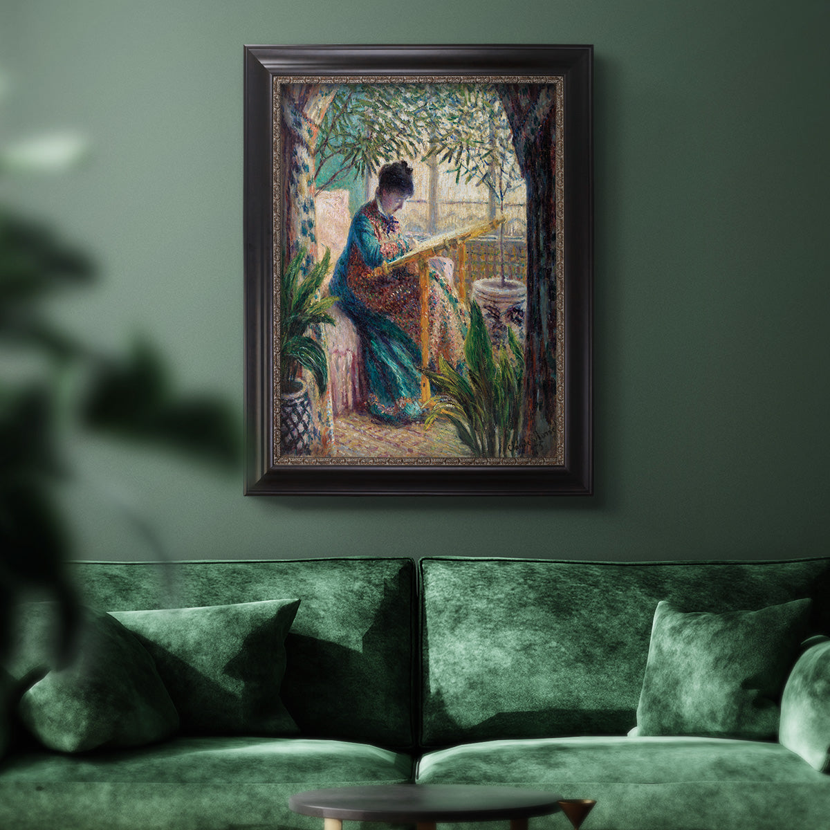 Impressionist portrait of Madame Monet sewing by Claude Monet in an ornate black frame with gilded inner detail displayed in a dark-toned interior setting.