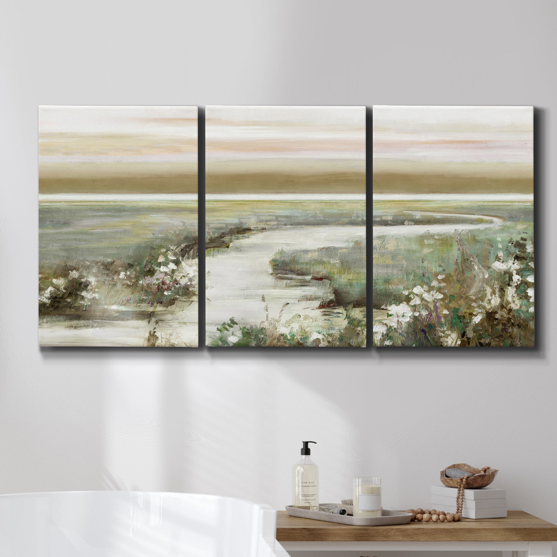 Three-panel canvas wall art featuring pastoral fields under soft sunrise, displayed in a bathroom above a bathtub.