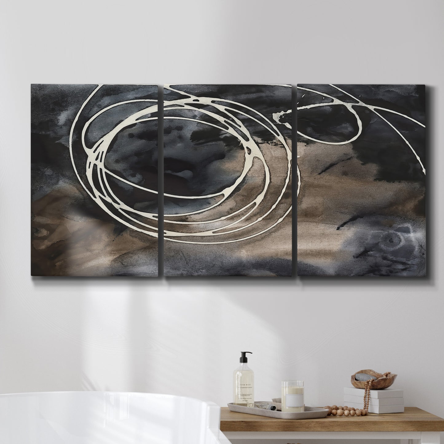 Three-panel canvas wall art featuring dark swirling abstract motion, displayed in a bathroom above a bathtub.