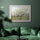 Impressionist white-blossomed orchard landscape by Vincent van Gogh in an ornate weathered white frame displayed in a dark-toned interior setting.