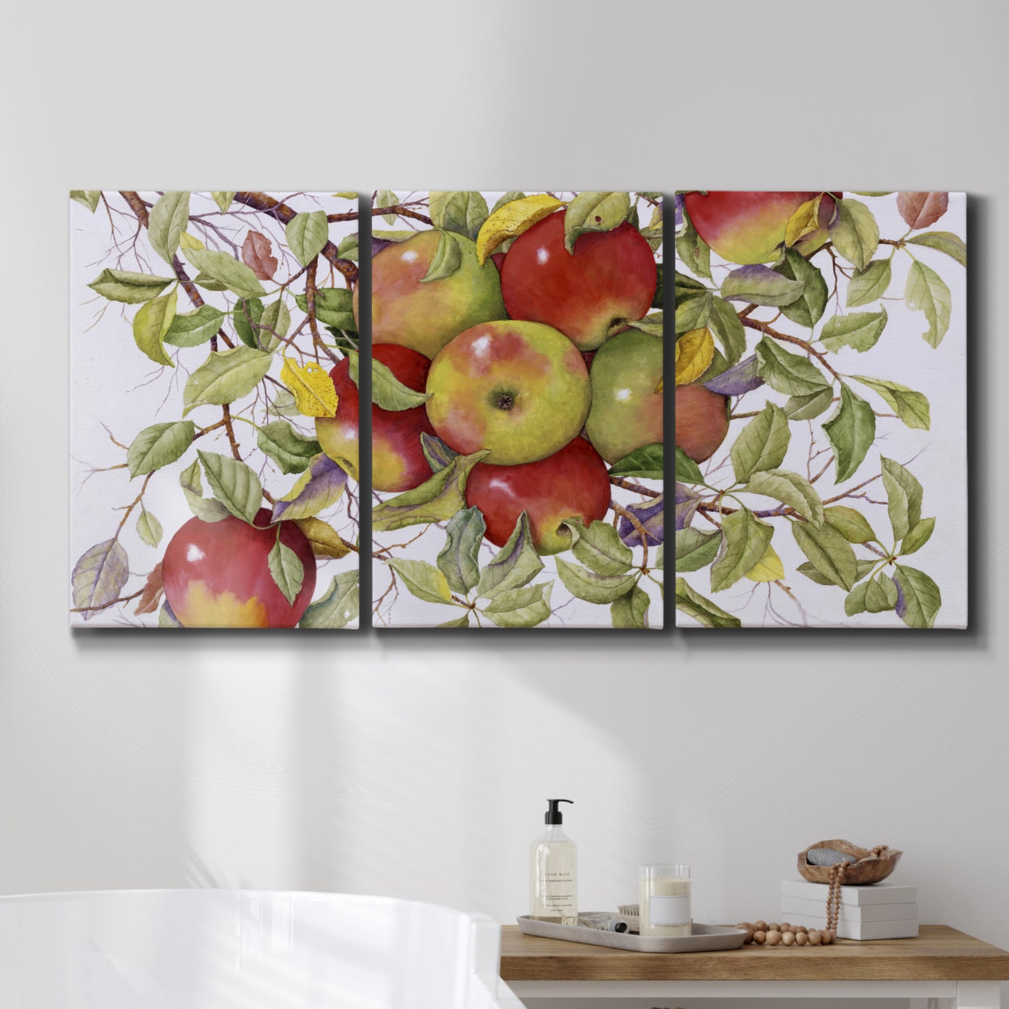 Three-panel canvas wall art featuring apples hanging from branch, displayed in a bathroom above a bathtub.