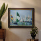 Coastal harbor watercolor painting in an ornate mahogany wood frame with gold liner displayed in a dark-toned interior setting.