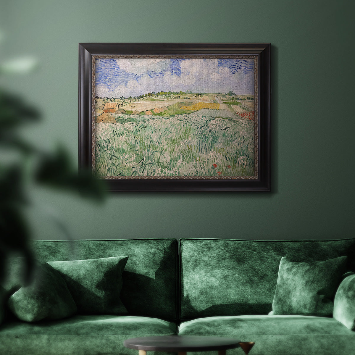 Impressionist countryside landscape near Auvers by Vincent van Gogh in an ornate black frame with gilded inner detail displayed in a dark-toned interior setting.