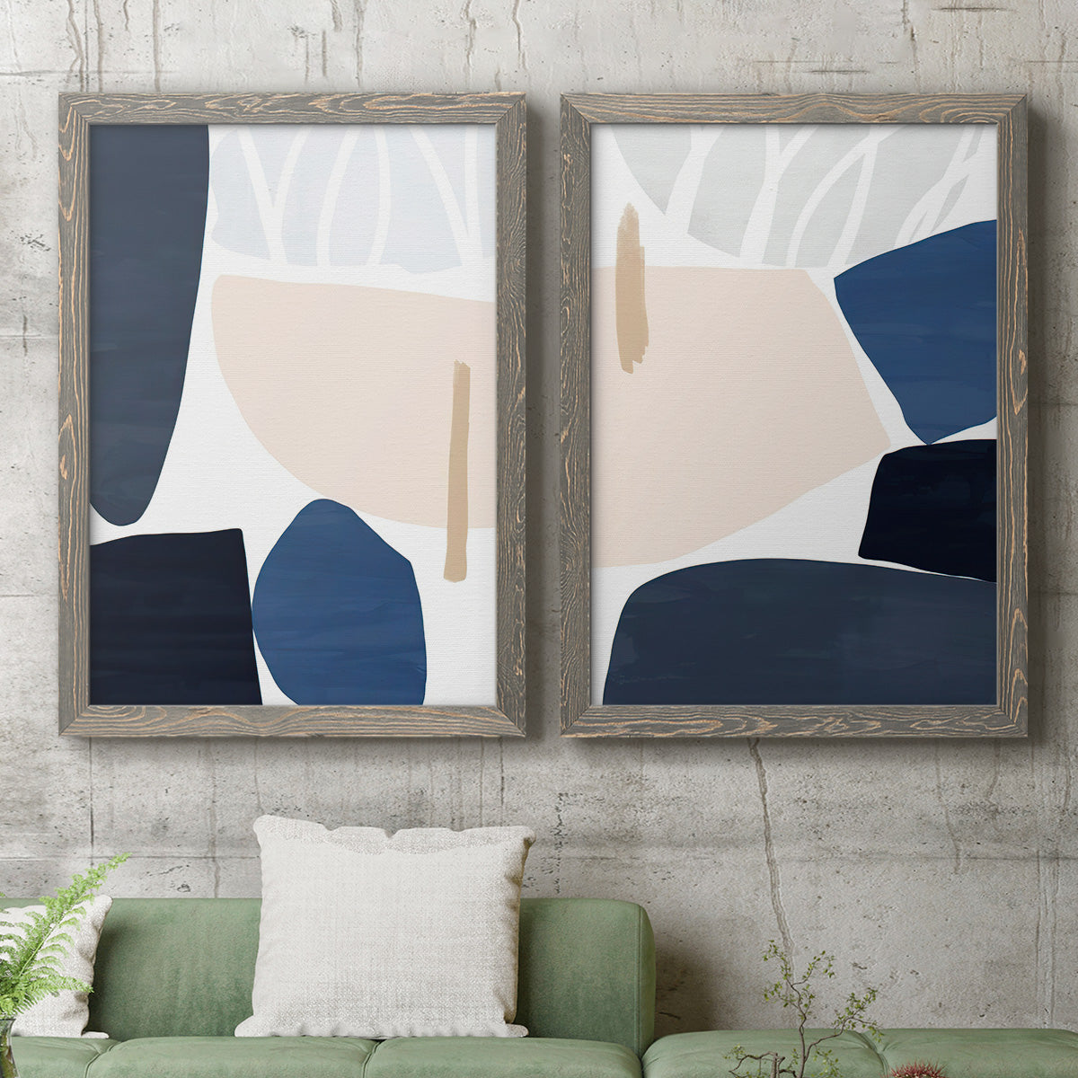 Set of two gray barnwood framed canvas prints depicting a coordinated art pair of large navy cream and beige organic geometric shapes rendered as minimalist color-block abstracts above a sofa in a modern living room.