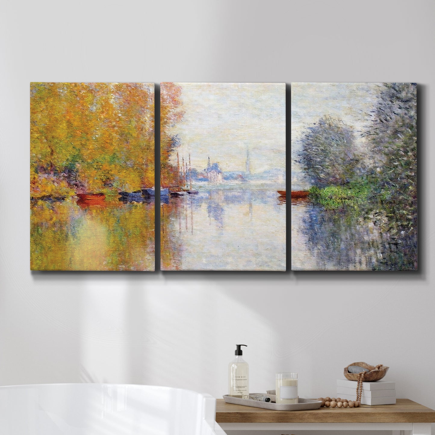 Three-panel canvas wall art featuring golden autumn light over riverside, displayed in a bathroom above a bathtub.