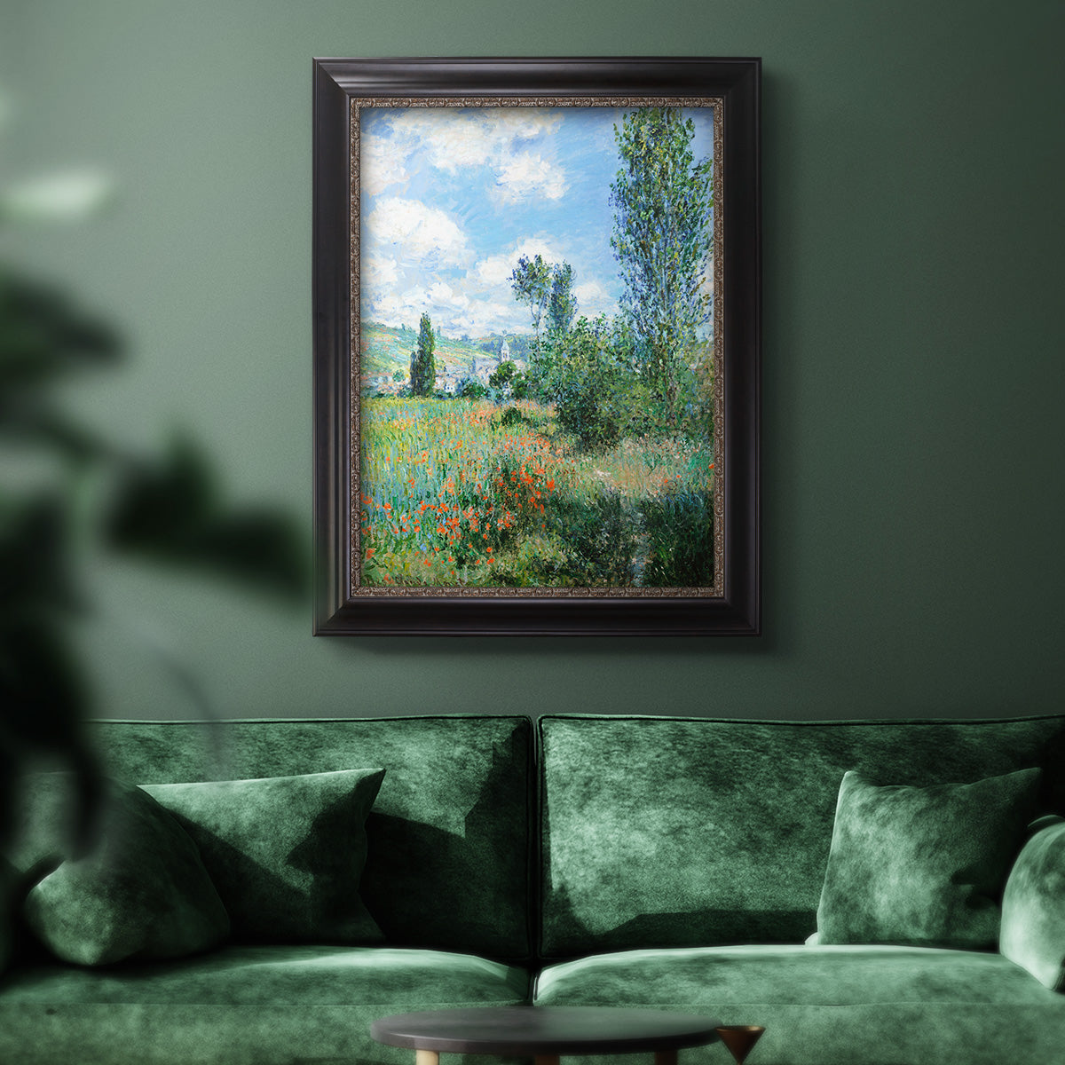 Impressionist pastoral landscape with poppy fields by Claude Monet in an ornate black frame with gilded inner detail displayed in a dark-toned interior setting.