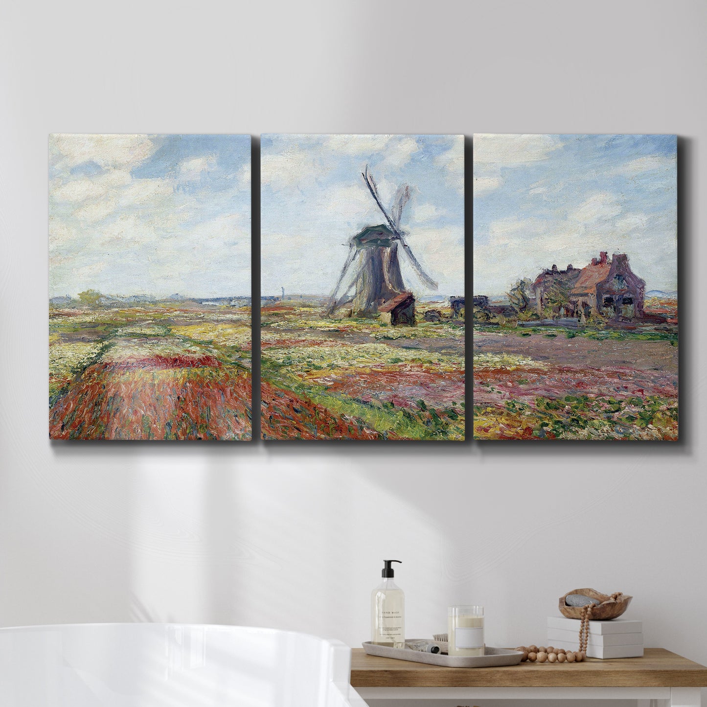 Three-panel canvas wall art featuring tulip fields with windmill, displayed in a bathroom above a bathtub.