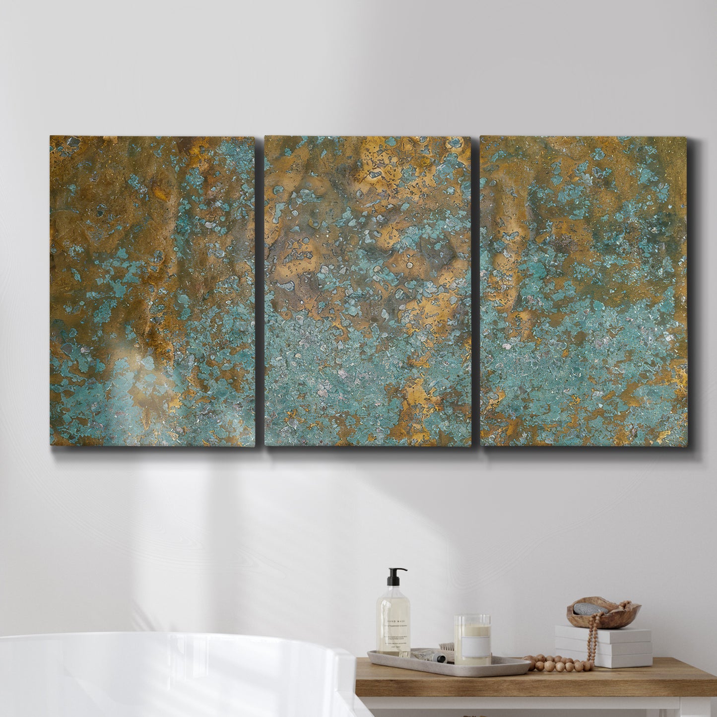 Three-panel canvas wall art featuring earthy copper toned abstract, displayed in a bathroom above a bathtub.