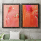 Set of two black barnwood framed canvas prints depicting a coordinated art pair of luminous coral orange and pink color fields with gold flecks rendered as glamorous fluid abstracts above a sofa in a modern living room.
