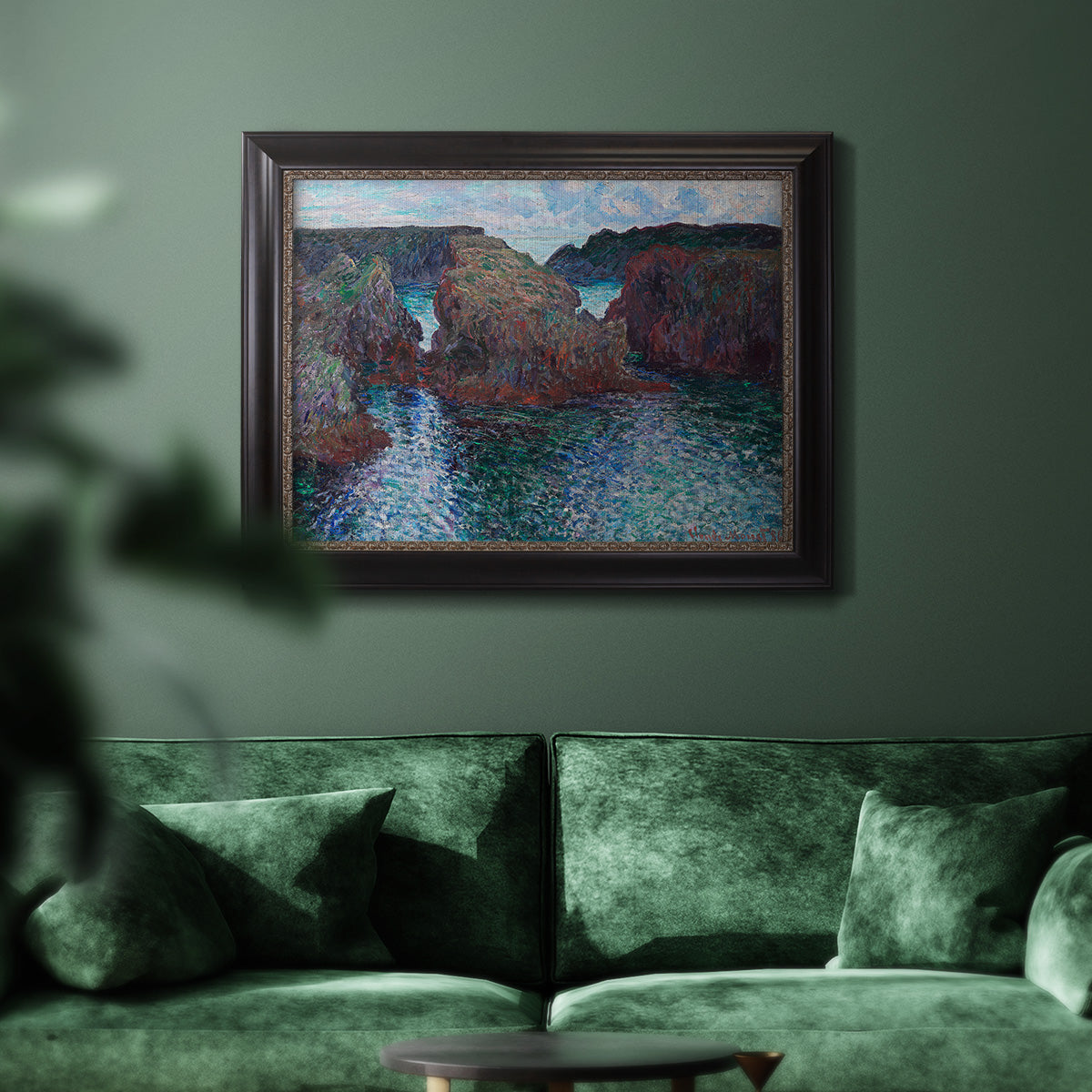 Impressionist rocky seascape by Claude Monet in an ornate black frame with gilded inner detail displayed in a dark-toned interior setting.