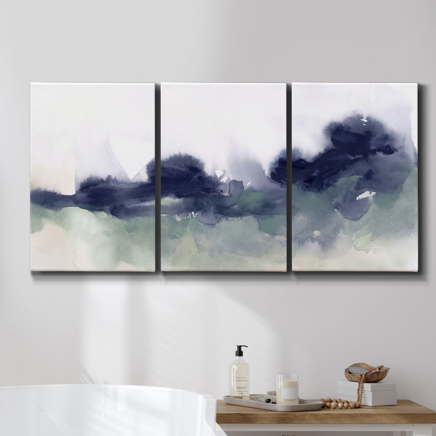 Three-panel canvas wall art featuring misty abstract lake watercolor, displayed in a bathroom above a bathtub.