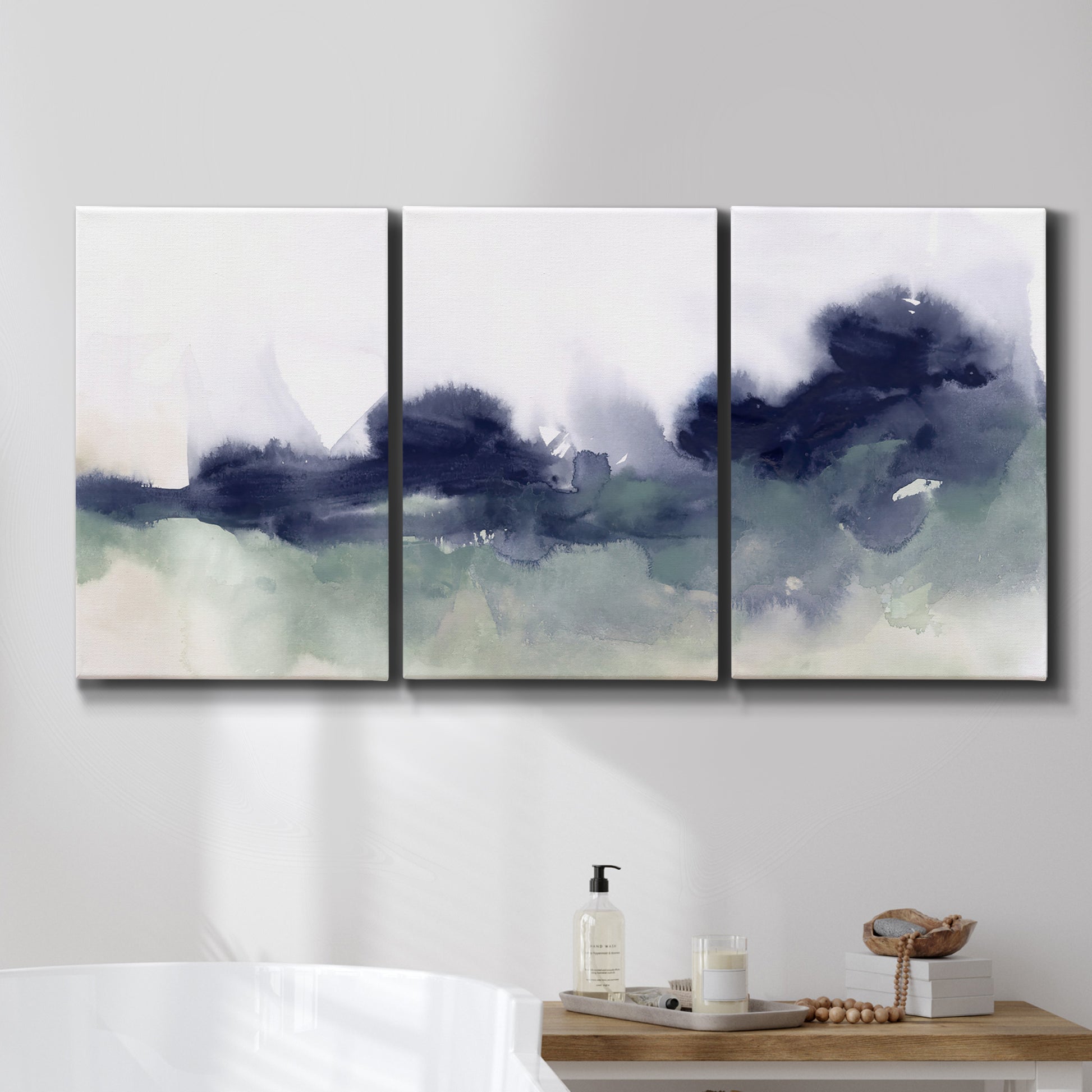 Three-panel canvas wall art featuring misty abstract lake watercolor, displayed in a bathroom above a bathtub.