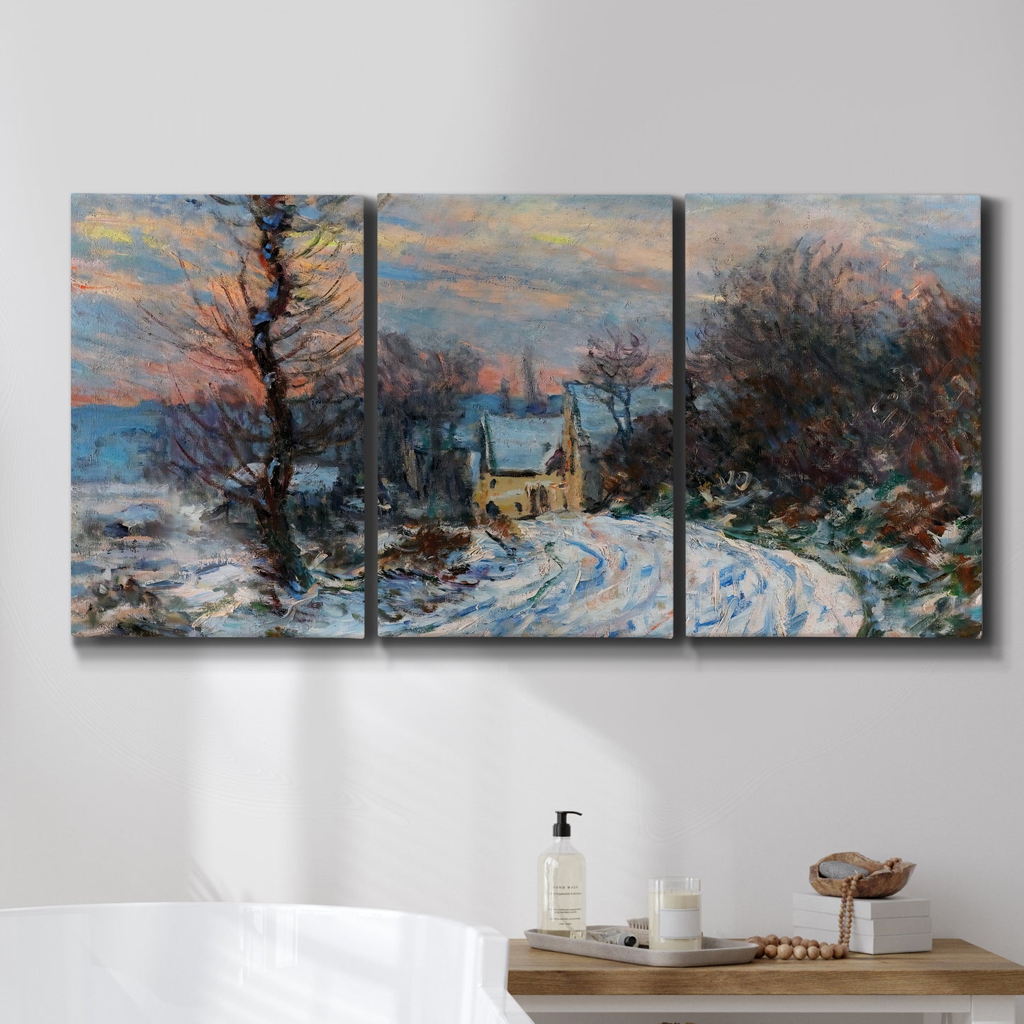 Three-panel canvas wall art featuring snow covered road leading to village, displayed in a bathroom above a bathtub.