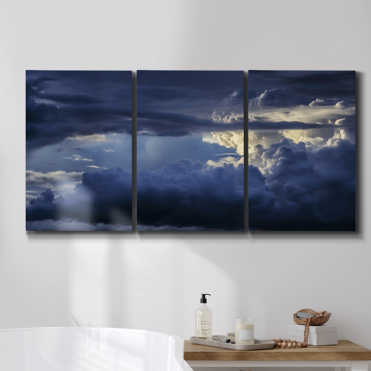 Three-panel canvas wall art featuring hot air balloons rising at dawn, displayed in a bathroom above a bathtub.