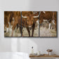 Three-panel canvas wall art featuring longhorn cattle standing together, displayed in a bathroom above a bathtub.