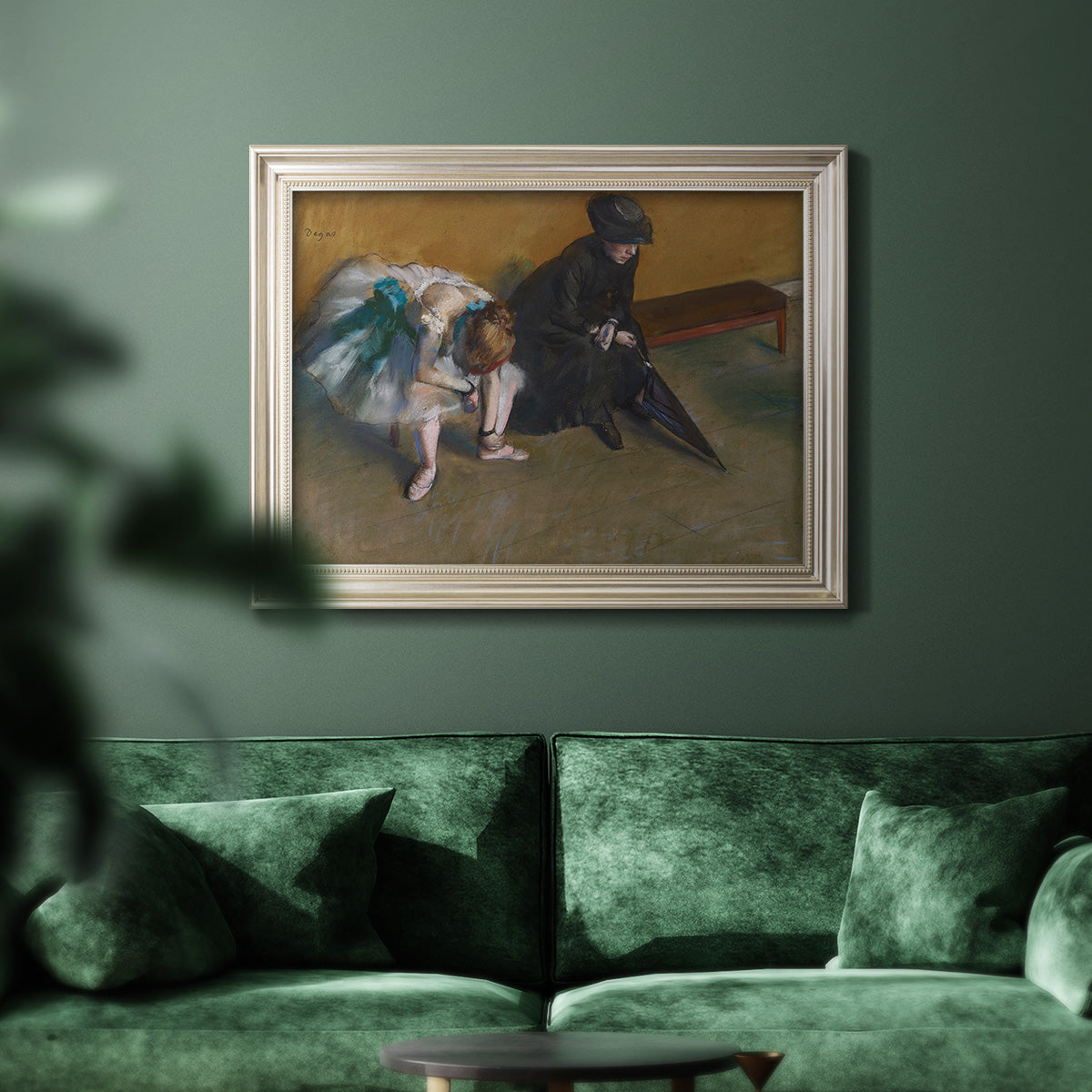 Impressionist portrait of a seated woman by Edgar Degas in an ornate champagne frame displayed in a dark-toned interior setting.