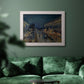 Impressionist nighttime Paris street scene by Camille Pissarro in an ornate weathered white frame displayed in a dark-toned interior setting.