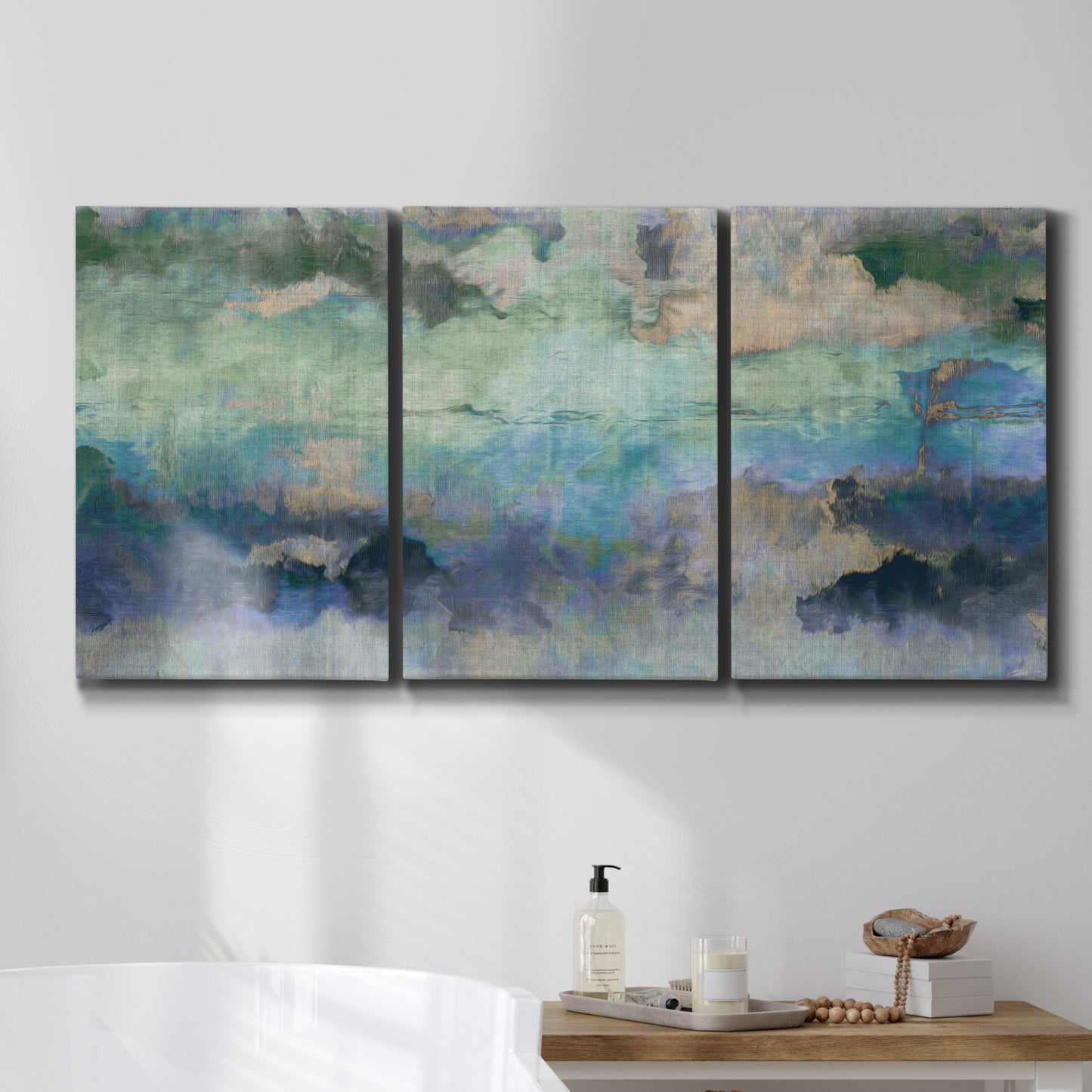 Three-panel canvas wall art featuring cool dreamy abstraction, displayed in a bathroom above a bathtub.