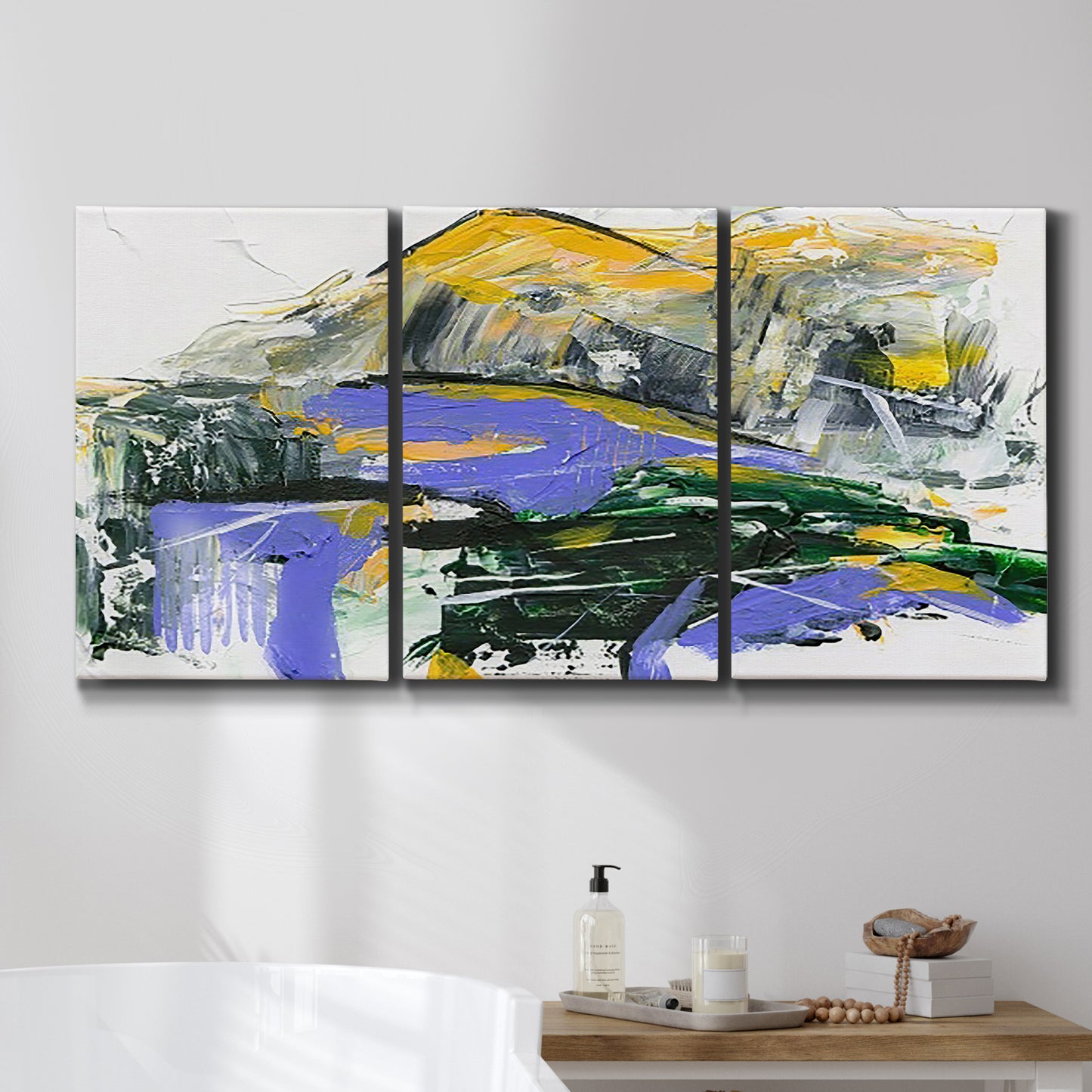 Three-panel canvas wall art featuring quiet abstract mountain silhouette, displayed in a bathroom above a bathtub.