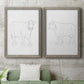 Set of two gray barnwood framed canvas prints depicting a coordinated art pair of simple contour drawings of standing cows rendered as minimalist livestock sketches above a sofa in a modern living room.